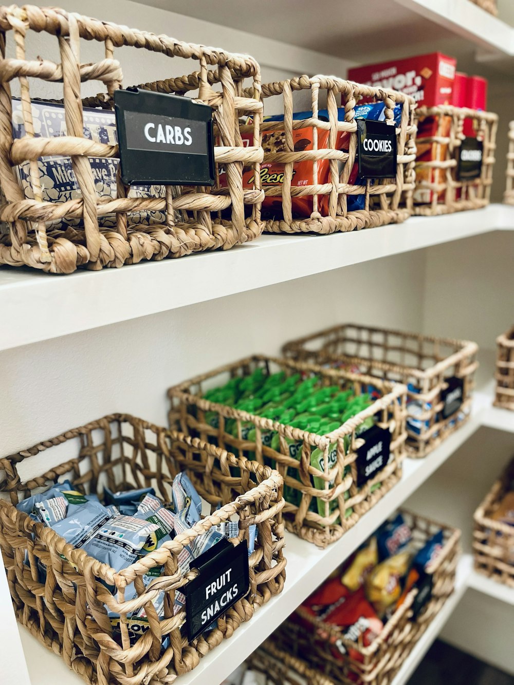 Baskets of packaged snacks arranged on pantry shelves